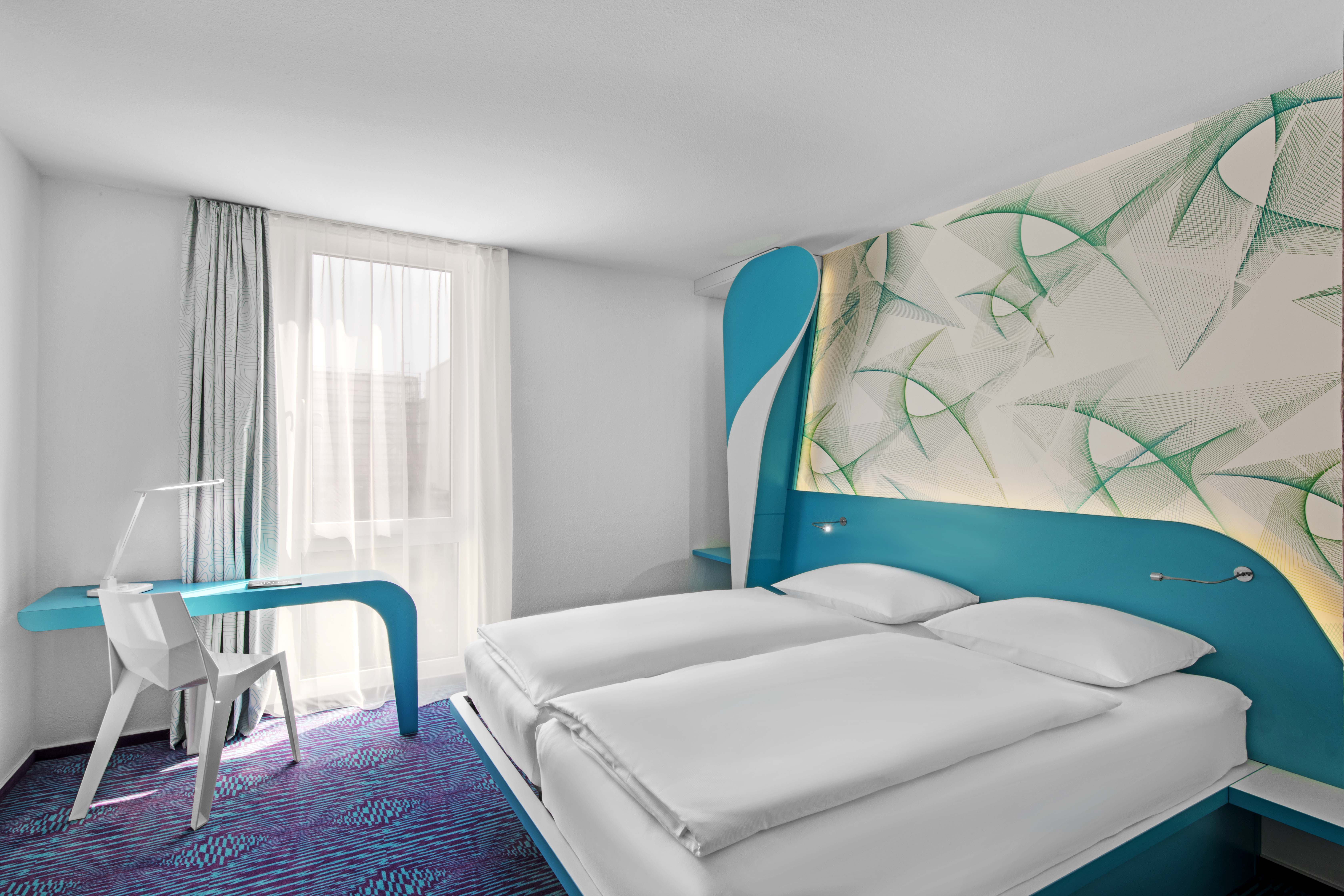 A modern double bedroom at prizeotel is pictured
